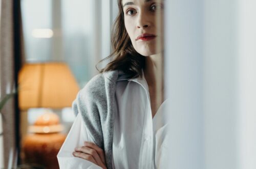 Mulher com os braços cruzados, pensativa